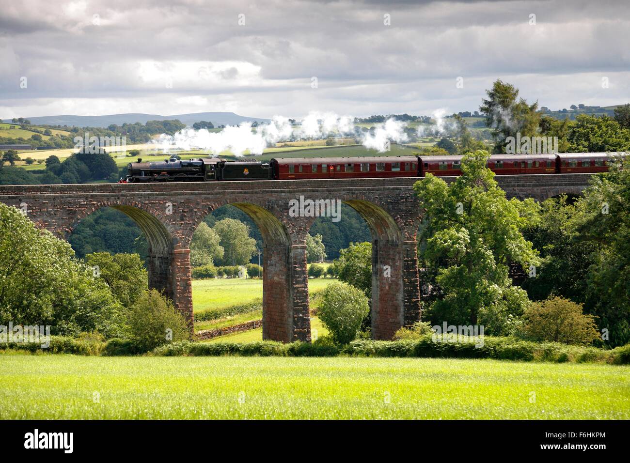 LMS Giubileo Classe Leander treno a vapore sul arrivino a Carlisle la linea ferroviaria su asciutto Beck viadotto nei pressi di Armathwaite, Cumbria. Foto Stock