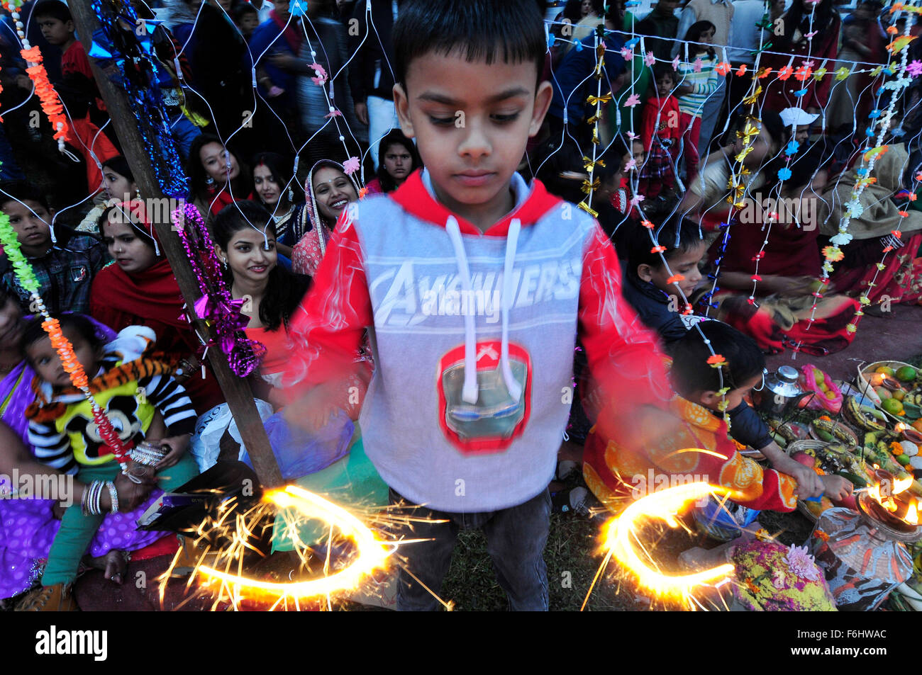 Kathmandu, Nepal. 17 Nov, 2015. Un capretto celebra dal fuoco ardente cracker come devoti eseguita rituali tradizionali a Rani Pokhari. Chhath Puja Festival, il culto del dio Sole, è comune in Nepal Terai della regione ed è celebrata in Kathmandu nonché dal Terai europee e in India. Il culto deve essere basata su uno stagno, un fiume o una qualsiasi fonte d'acqua, come per la tradizione religiosa. (Foto di Narayan Maharjan / Pacific Stampa) Credito: PACIFIC PRESS/Alamy Live News Foto Stock