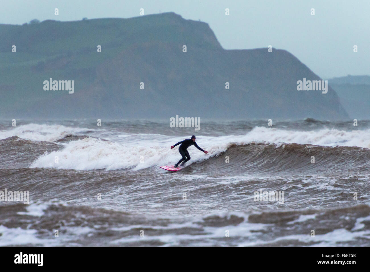 Regno Unito Meteo, Lyme Regis, Dorset, Regno Unito. 17 novembre 2015. Un surfista godendo le onde al largo della costa di Lyme Regis in Dorset, Regno Unito, durante una giornata di forte vento e mare mosso causato dalla tempesta Barney. Immagine: ©Graham Hunt/Alamy Live News Foto Stock