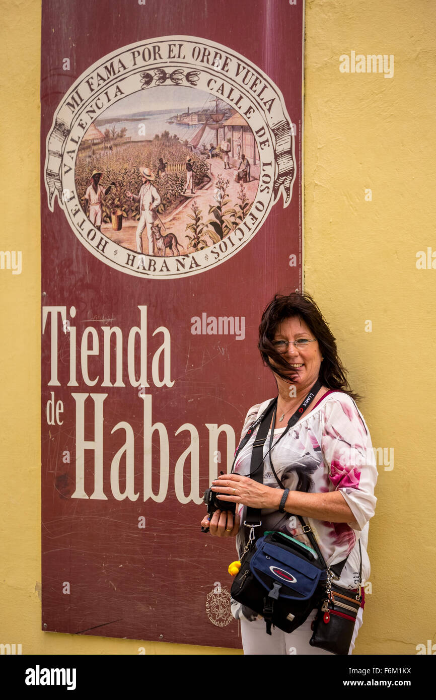 I turisti con la fotocamera davanti a un negozio di sigari e tabacco manifesti davanti a un sigaro cubano business, manifesti pubblicitari, Foto Stock