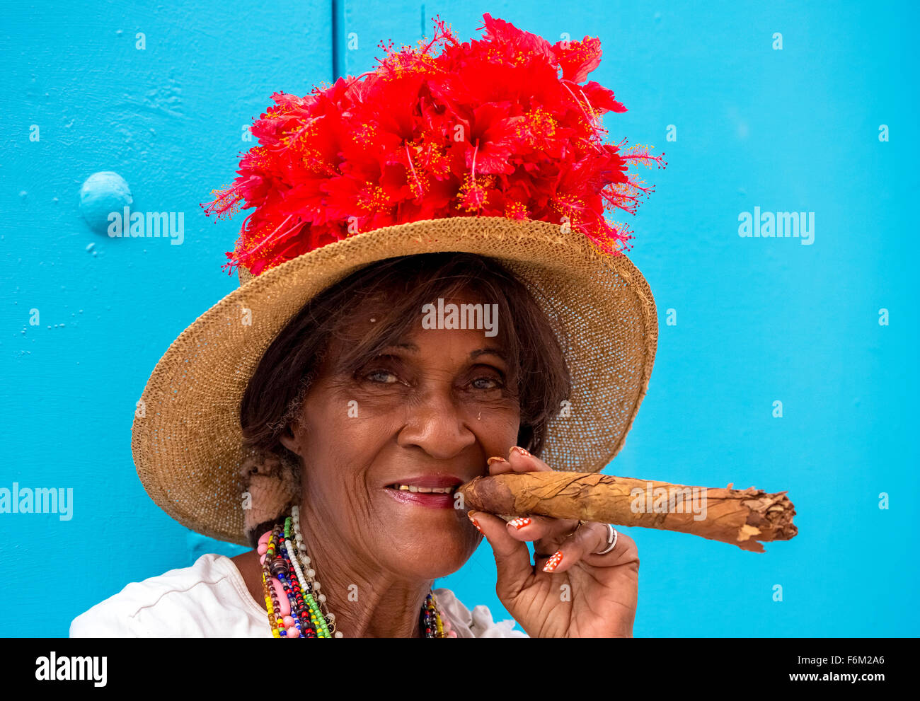 Vecchia donna cubana fuma sulla strada di un sigaro cubano e post con il suo gatto per i turisti, Cuba, Nord America, Caraibi Foto Stock