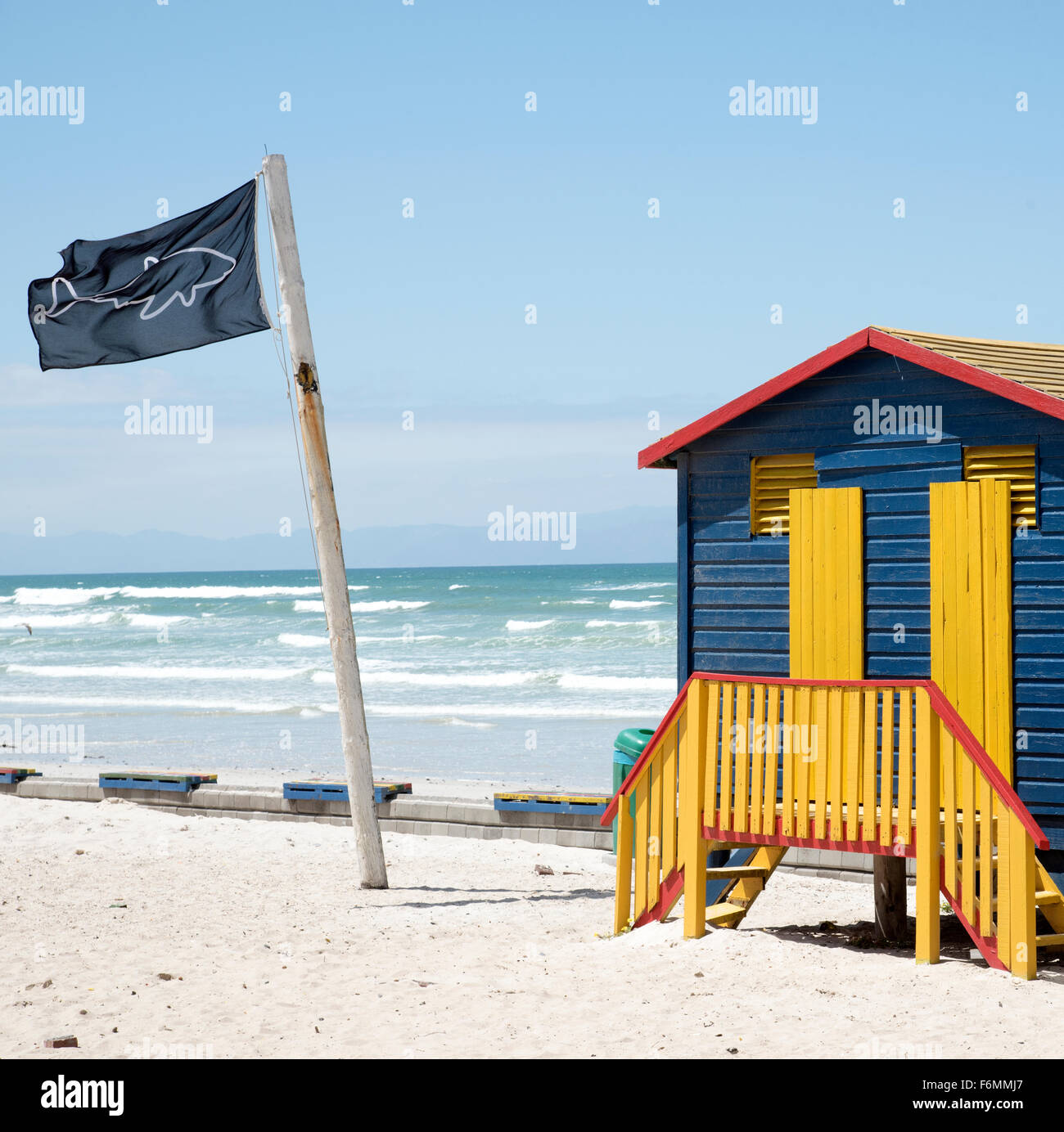 Pittoresca spiaggia di capanne in Muizenberg località balneare vicino a Città del Capo in Sud Africa e in uno squalo punto di osservazione bandiera Foto Stock