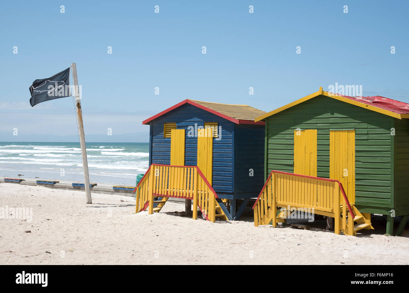 Pittoresca spiaggia di capanne in Muizenberg località balneare vicino a Città del Capo in Sud Africa e in uno squalo punto di osservazione bandiera Foto Stock