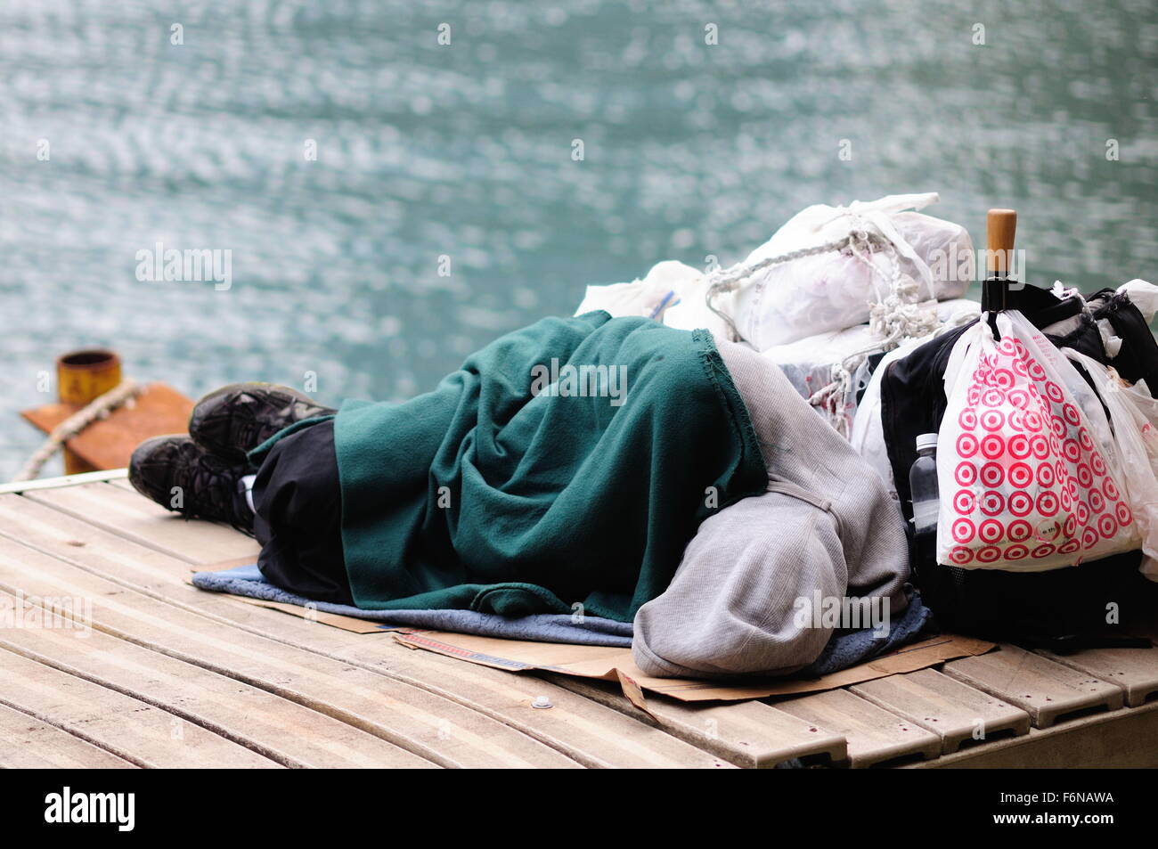 Un senzatetto uomo dorme su un materasso di cartone lungo il fiume Chicago al Lake Shore Drive cavalcavia. Chicago, Illinois, Stati Uniti d'America. Foto Stock