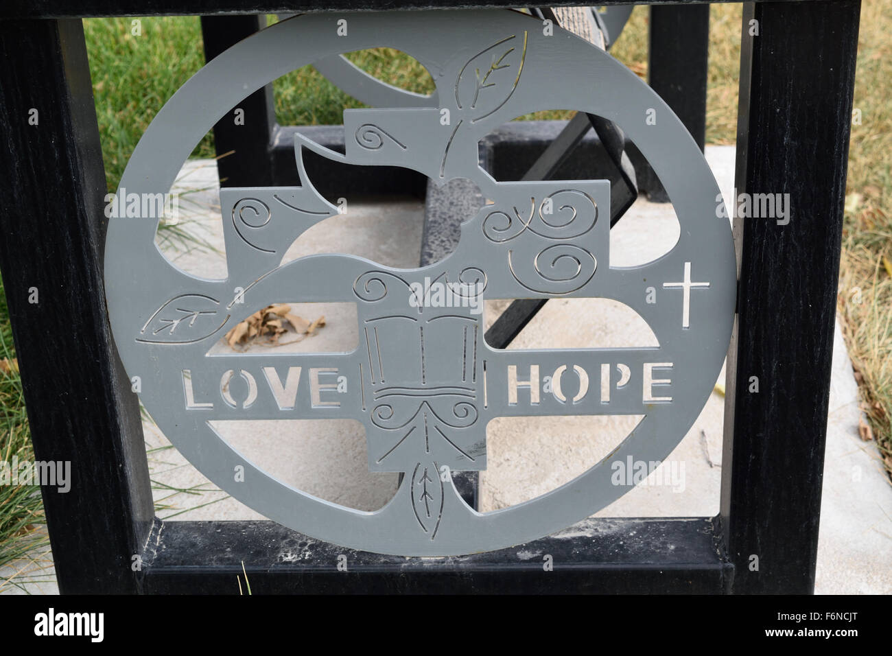 Scultura di metallo di amore e di speranza la frase sul fondo della campana nella parte anteriore di una chiesa. Foto Stock