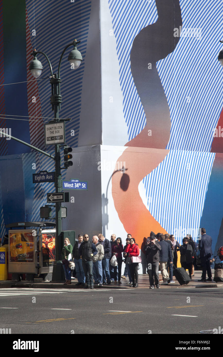 La gente in attesa di attraversare 8 Ave. a 34th Street sul lato ovest di Manhattan. Foto Stock