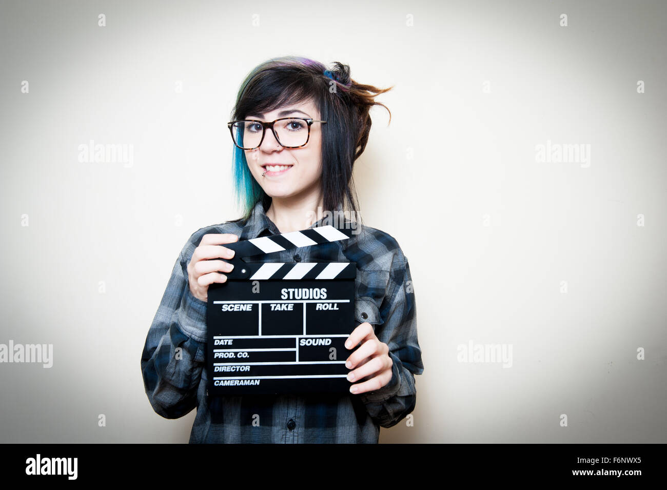 Sorridente teen donna con movie clapper board su bianco Foto Stock