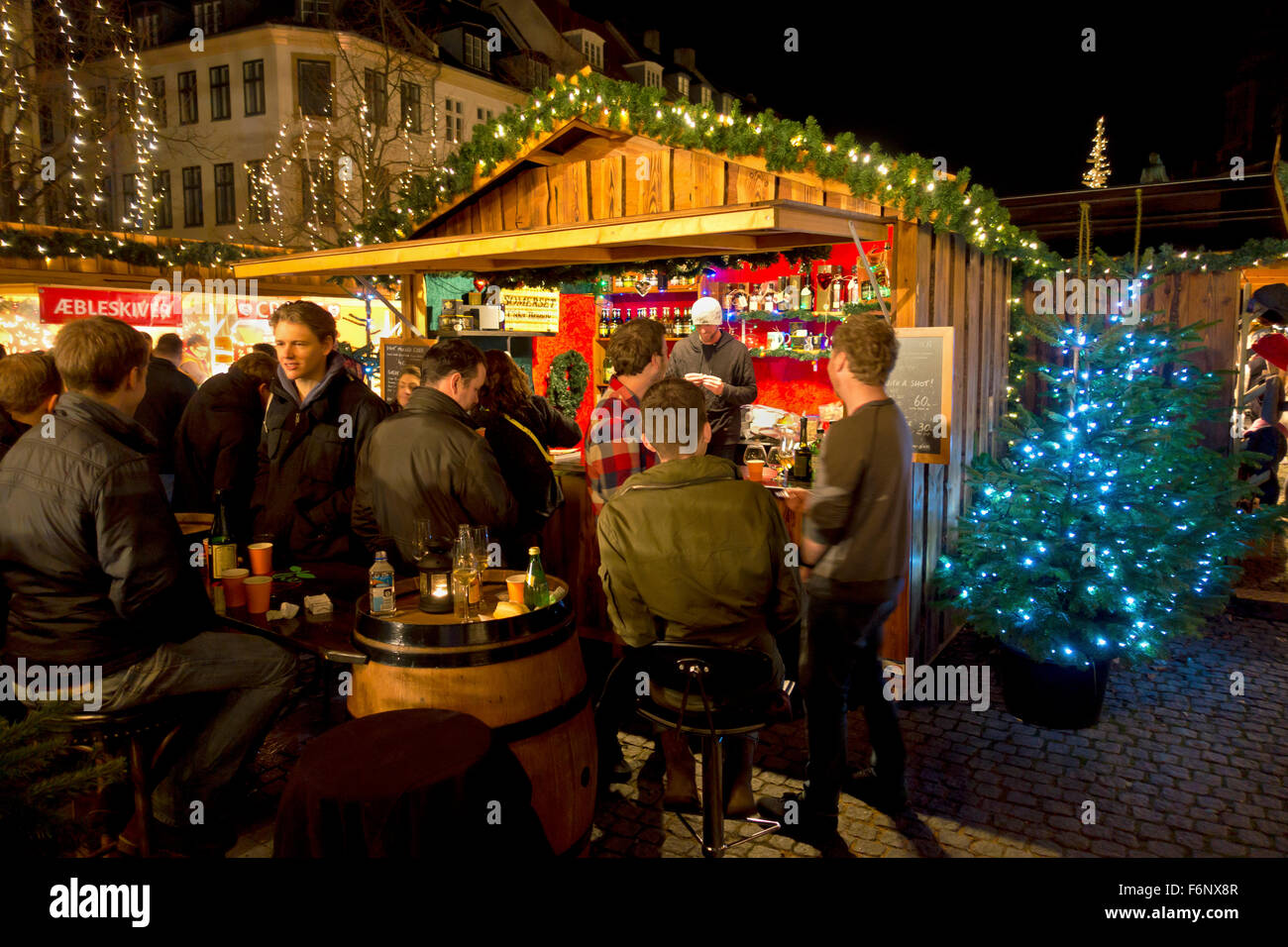 I giovani bevono un drink al mercatino di Natale di Højbro Plads (Piazza Hoejbro) a Strøget a metà novembre. Hygge Di Natale. Ambiente. Foto Stock