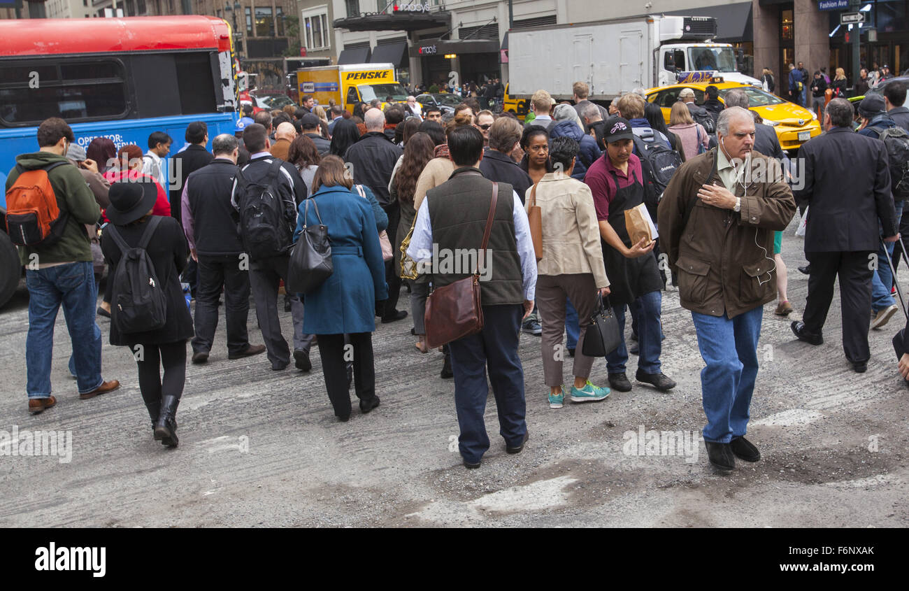 Mattina Rush Hour folle di edificio per uffici lavoratori cross 34th Street e la 7th Avenue in Manhattan. Foto Stock