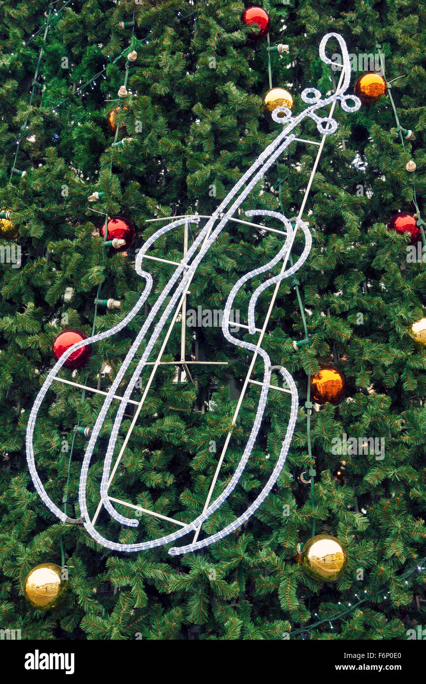 Sfondo di natale della pubblica albero di Natale decorato con il rosso e il giallo di sfere e violino fatto di incandescente STRISCIA DI LED Foto Stock
