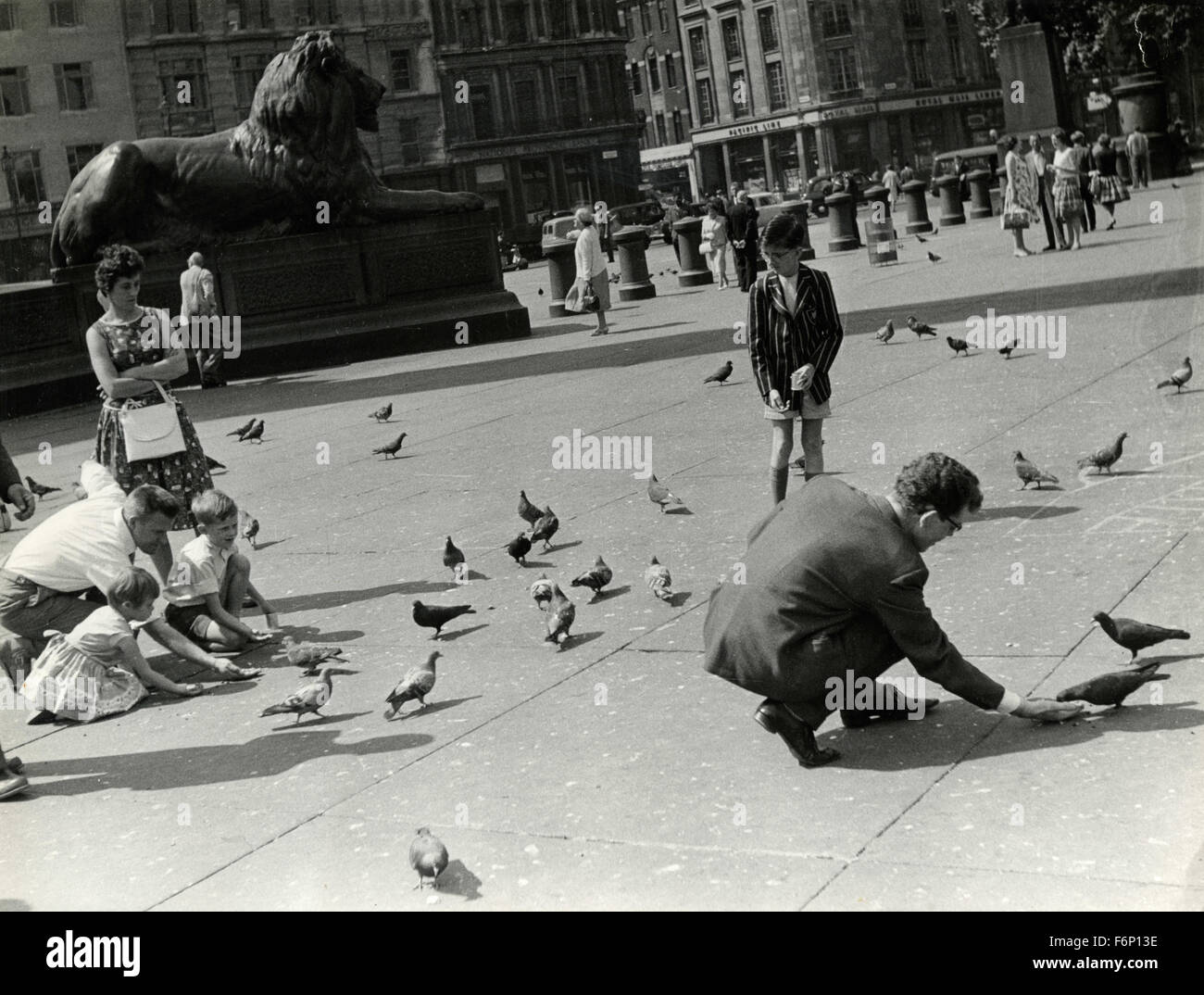 Bambini che giocano con i piccioni in Trafalgar Square, London, Regno Unito Foto Stock