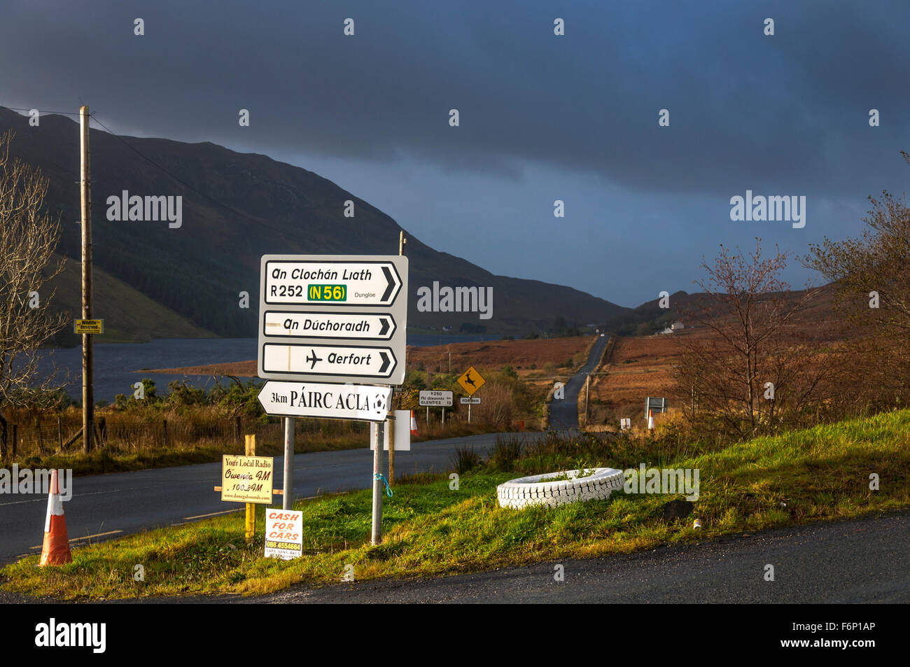 Linguaggio gaelico cartello stradale a Fintown, County Donegal, Irlanda. Il paesaggio in novembre. Foto Stock
