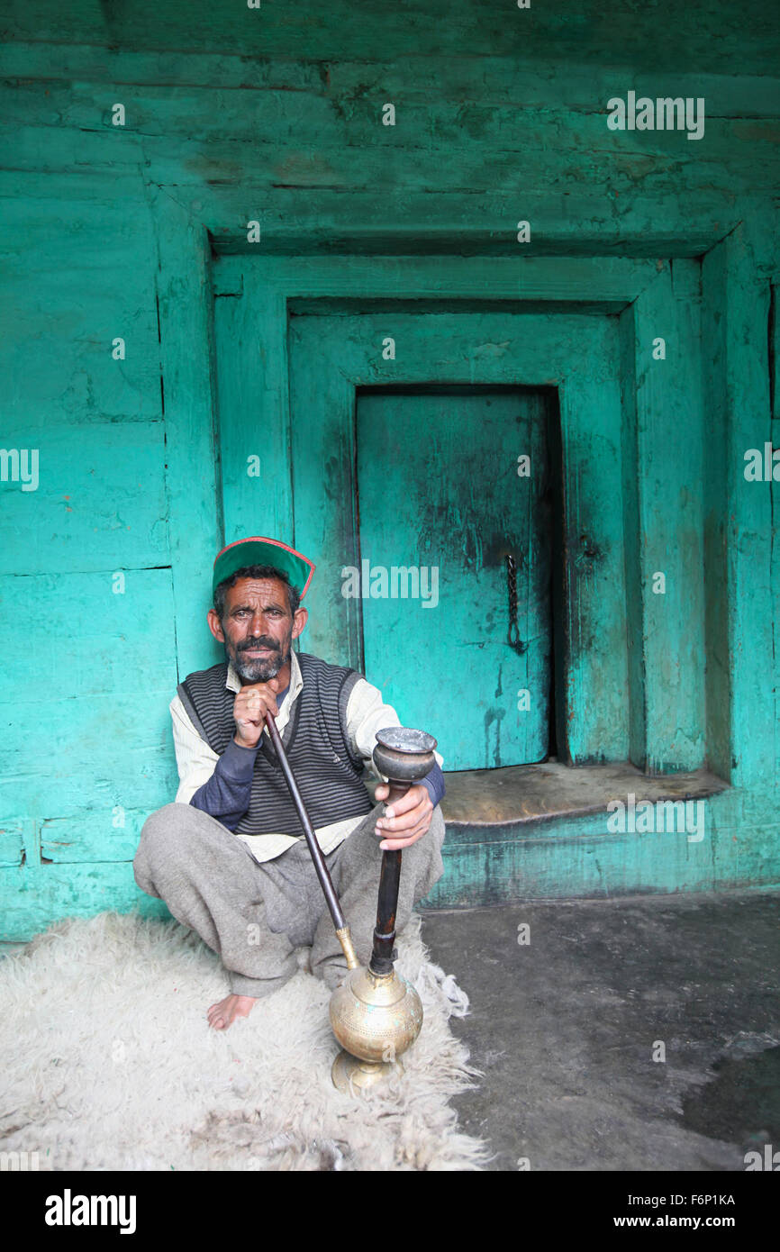 SPITI VALLEY, uomo godendo hukka nella sua casa di villaggio Rakchham in Himachal Pradesh in India Foto Stock
