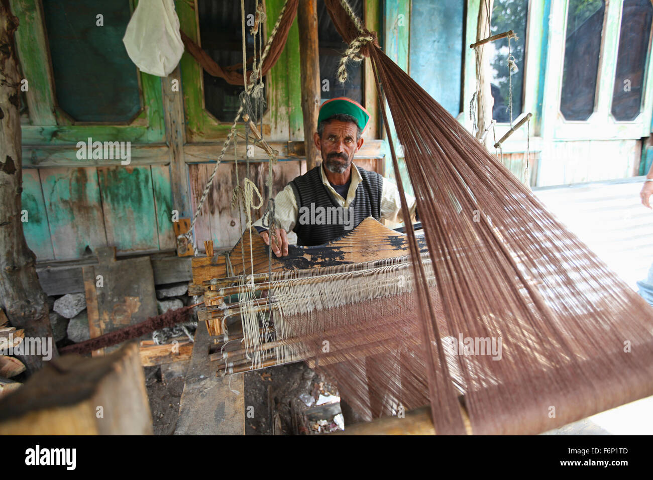 SPITI VALLEY, uomo ( di tessitura lavorando su tessuti prodotti su telai a mano ) nella sua casa di villaggio Rakchham, Sangla, Himachal Pradesh, India Foto Stock