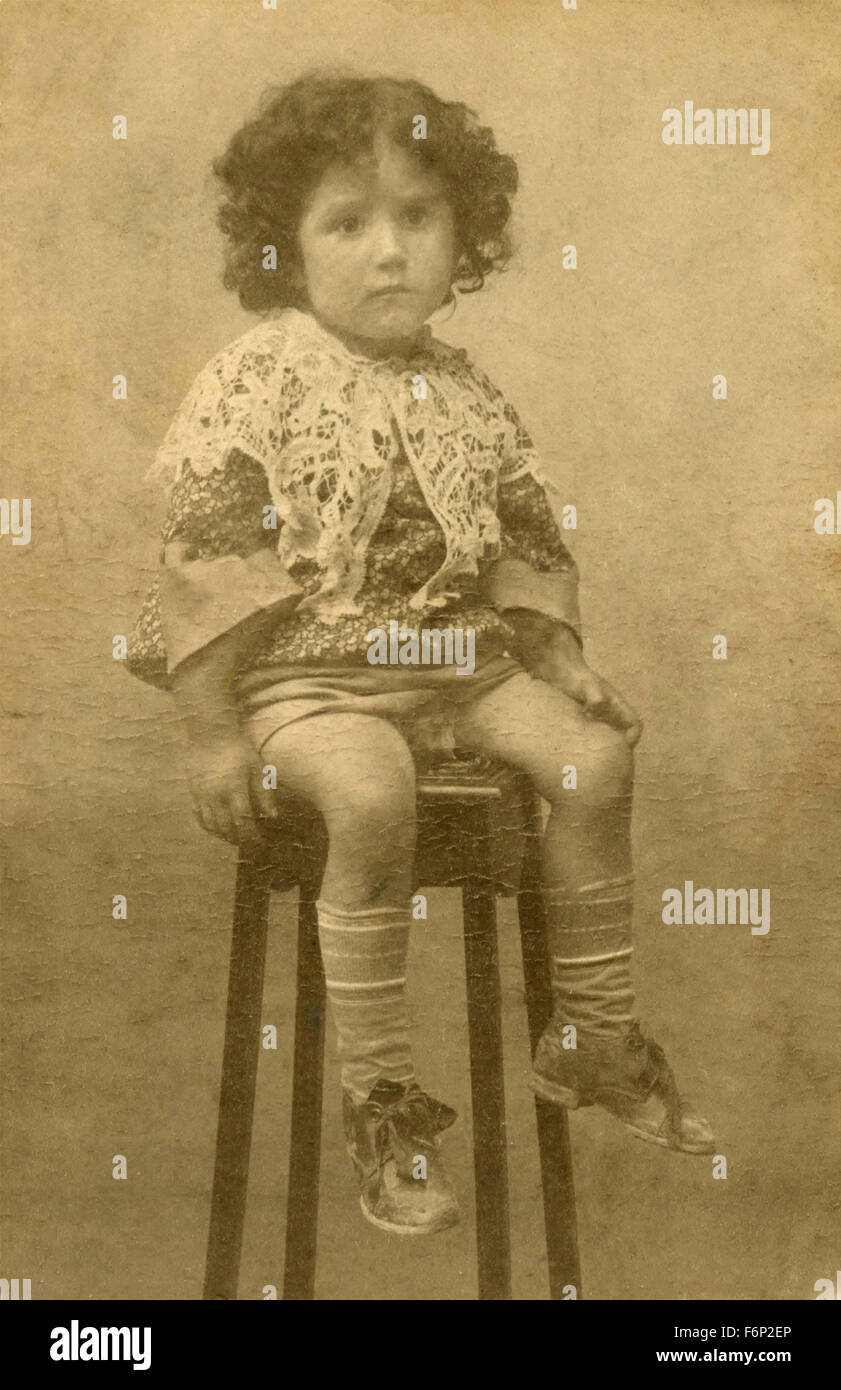 Ritratto di una bambina seduta su uno sgabello, Italia Foto Stock