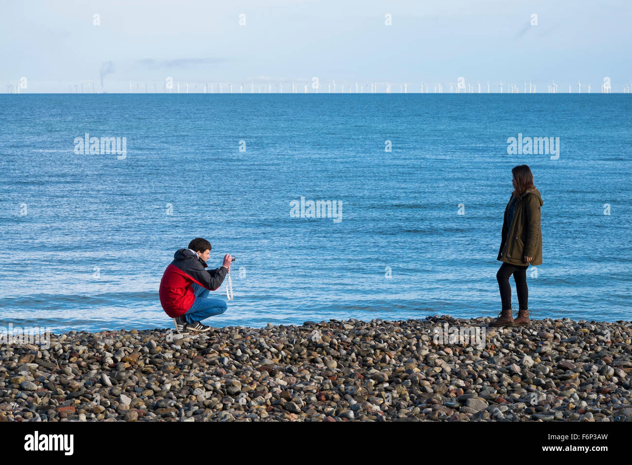 Un uomo di scattare una foto di una donna sulla spiaggia di Llandudno, Conwy, Wales, Regno Unito Foto Stock