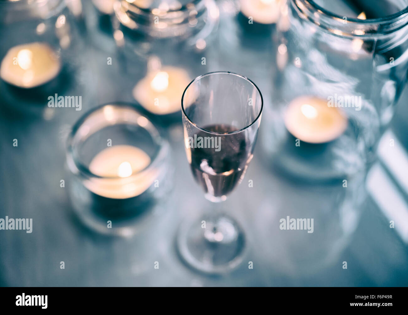 Vino rosso e tè accendono le candele in vasetti di vetro. Foto Stock