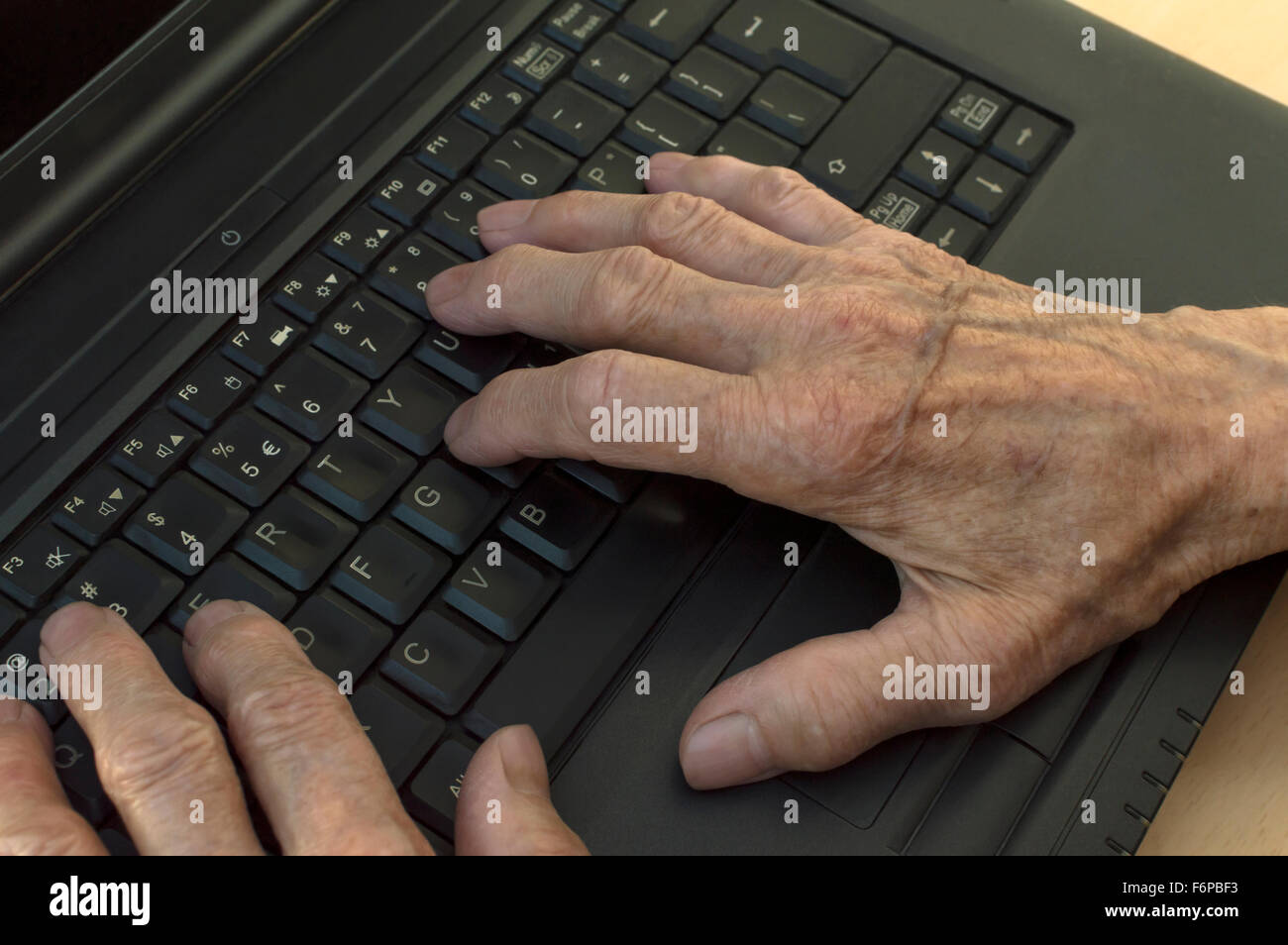 Primo piano su anziani le mani sulla tastiera del laptop. Messa a fuoco selettiva. Foto Stock