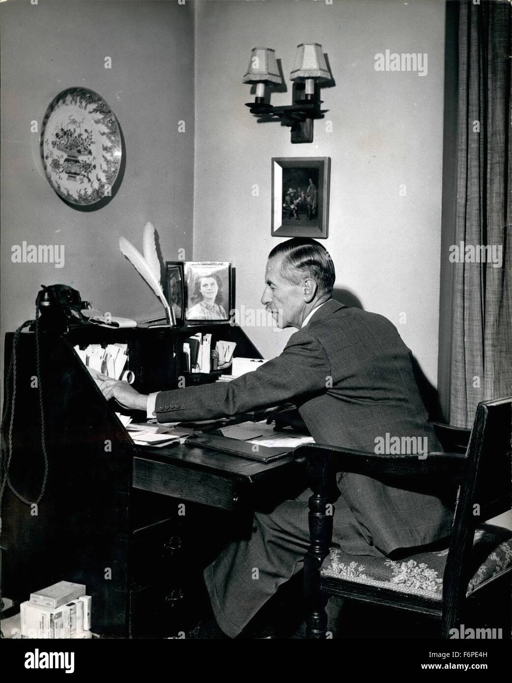 1957 - Londra è di nuovo Sindaco fa alcuni dei suoi lavori nella sua casa di accoglienza: Sir Noel Vansittart Bowater fa alcuni dei suoi lavori presso il bureau scrivania nella sua St. George's Hill, Waybridge home, sul quale egli mantiene le foto di famiglia, quill penne, libri di impegno che sono rapidamente riempiendo. (Credito Immagine: © Keystone Pictures USA/ZUMAPRESS.com) Foto Stock