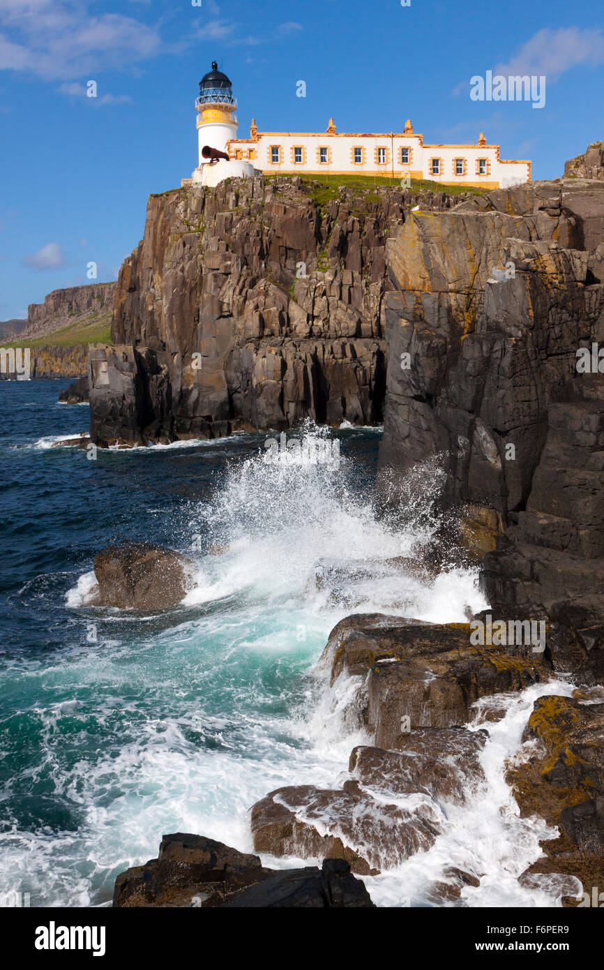 Neist Point lighthouse sull isola di Skye, con si infrangono onde del mare sotto le scogliere Foto Stock