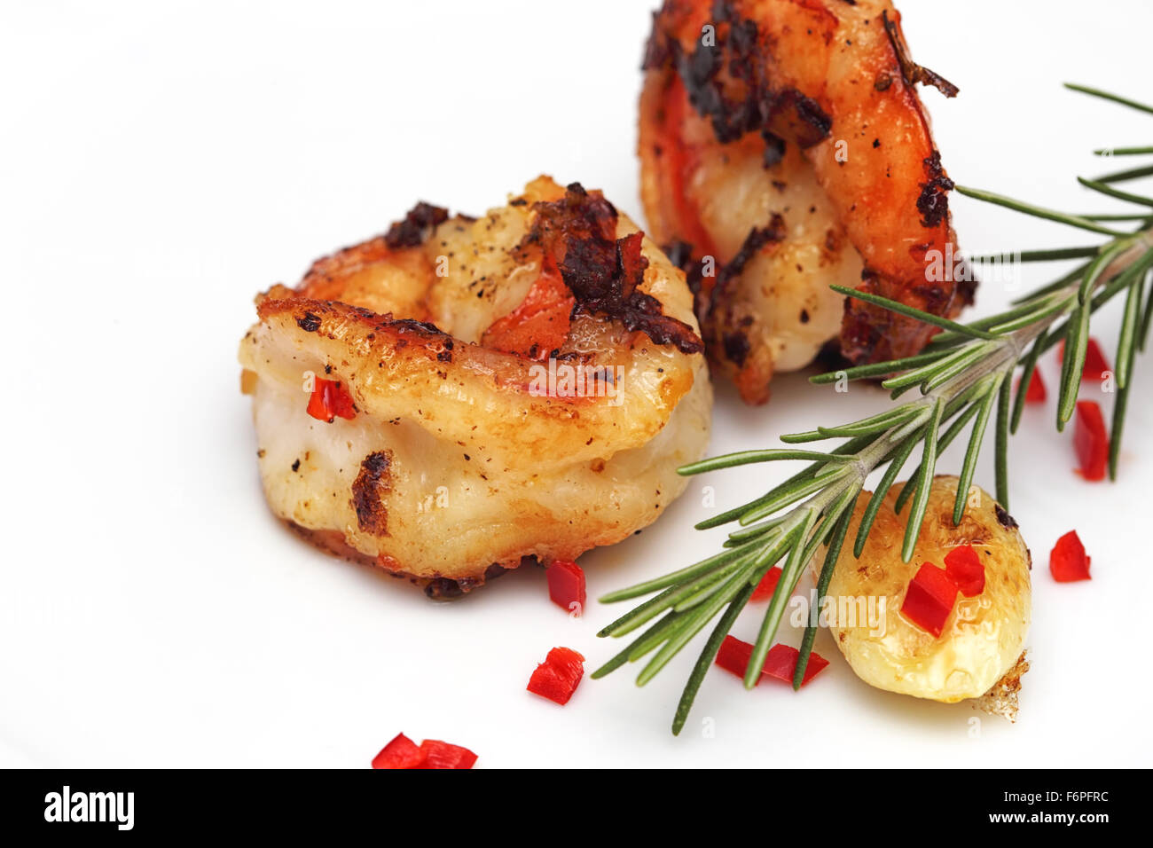 Grigliata gigante pelati di gamberi con rosmarino, aglio e peperoncino rosso su sfondo bianco. Foto Stock