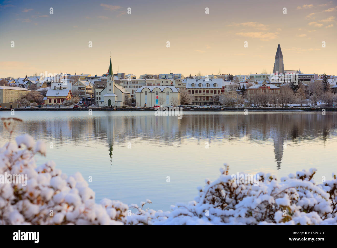 La città di Reykjavik lago Tjörnin in autunno dopo la caduta di neve che mostra la famosa chiesa Hallgrimskirkja all'orizzonte. Foto Stock