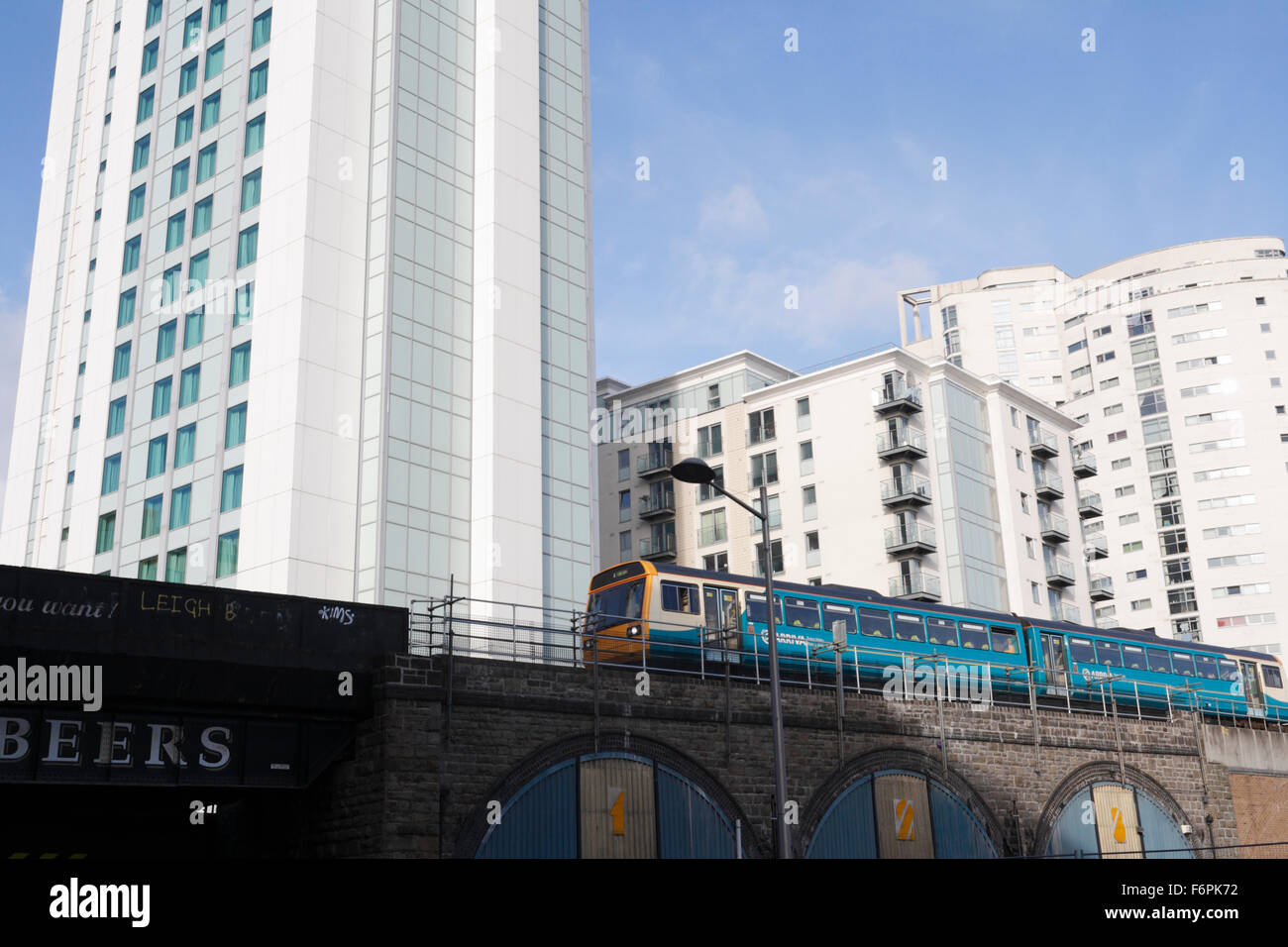 Arriva il treno passeggeri nel centro di Cardiff Galles, edifici alti sfondo Foto Stock