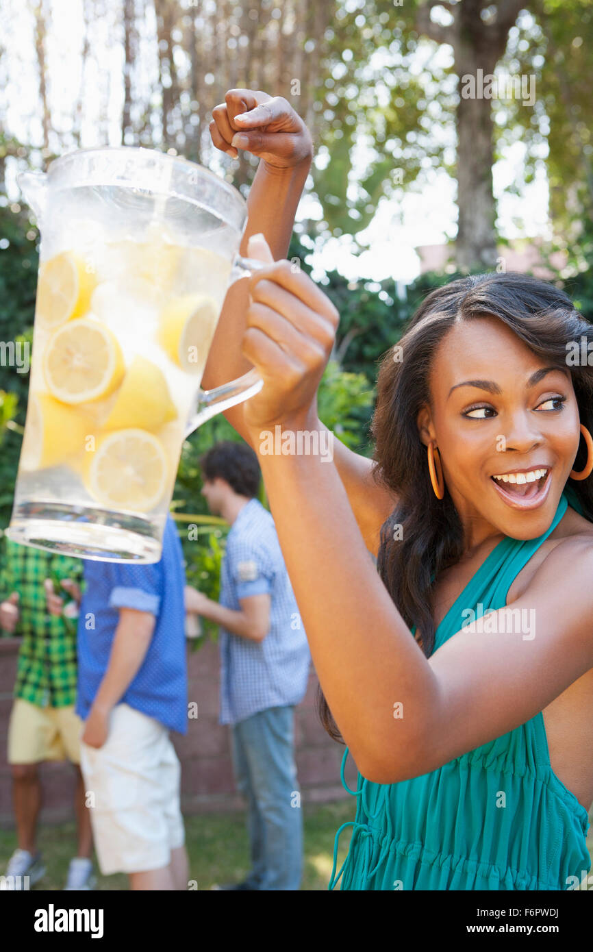 Donna che mantiene brocca di limonata al barbecue nel cortile Foto Stock