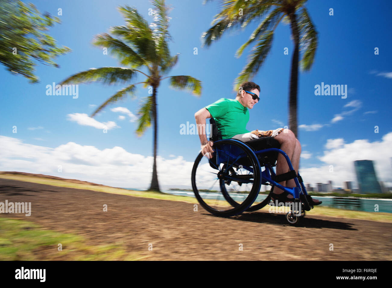 Disabilitato l'uomo racing in carrozzella da urban beach Foto Stock