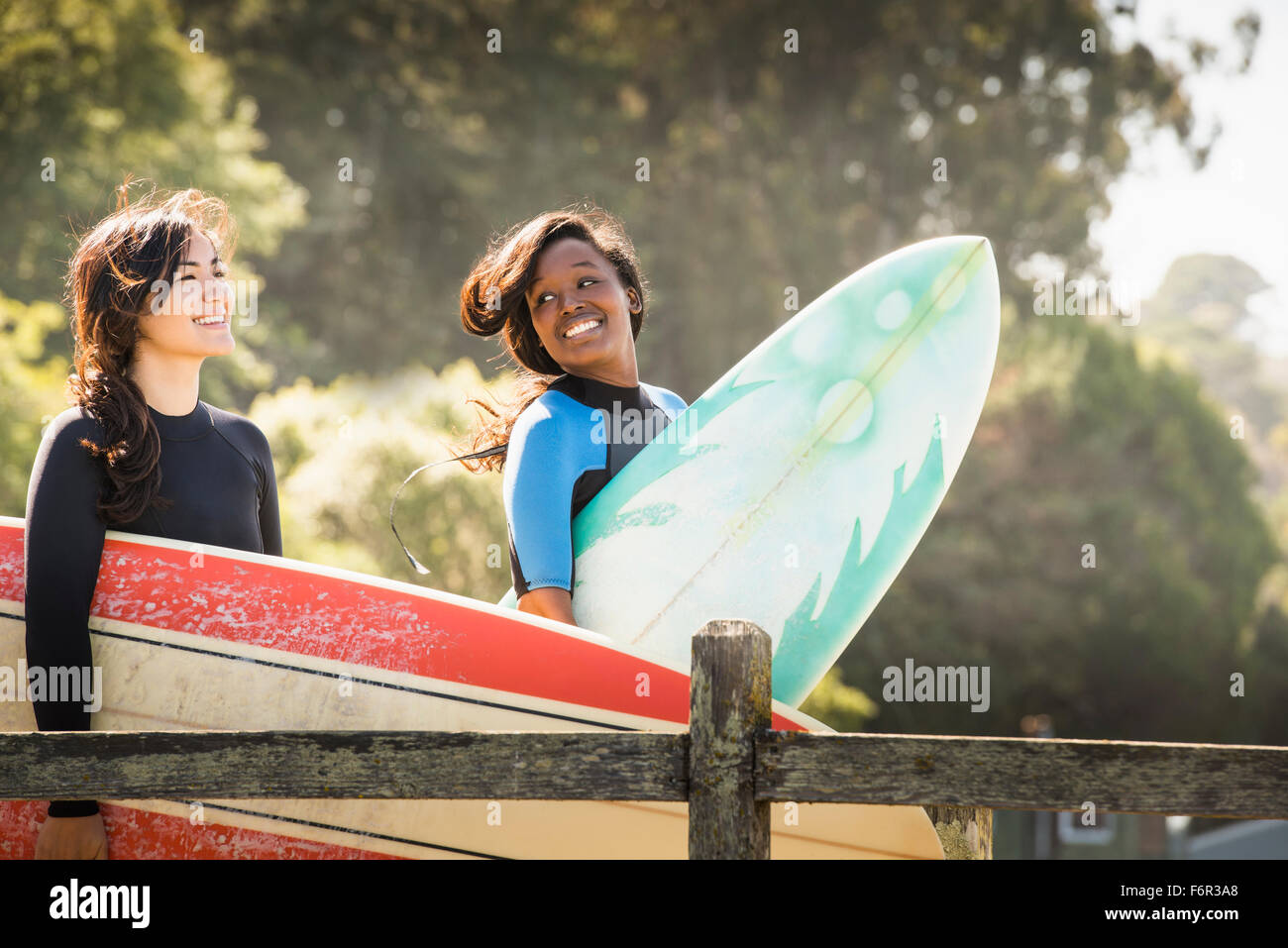 Le donne che trasportano le tavole da surf all'aperto Foto Stock