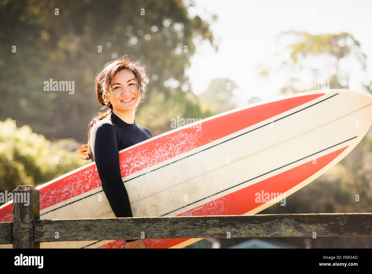 Donna che trasportano le tavole da surf all'aperto Foto Stock