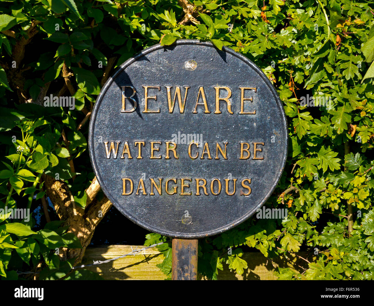 Attenzione l'acqua può essere pericoloso circolare segno di avvertimento accanto al canale Foto Stock