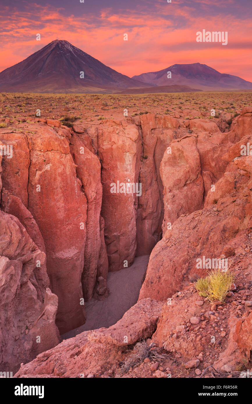 Uno stretto canyon con un vulcano in distanza. Fotografato a piedi del Volcan Licancabur nel deserto di Atacama, northern ch Foto Stock