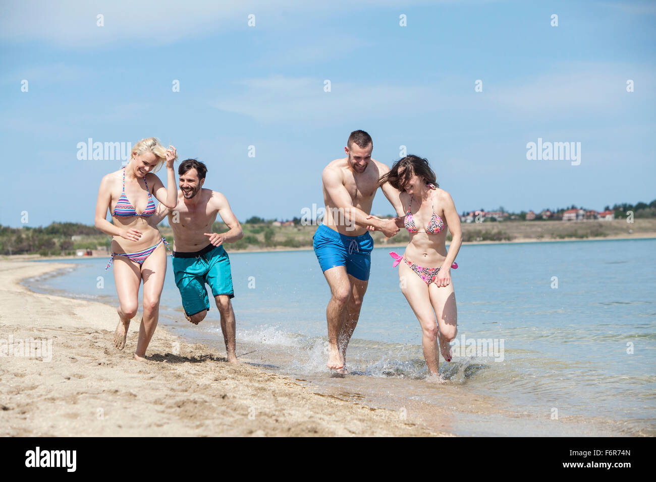 Gruppo di amici sulla spiaggia ingannare circa Foto Stock
