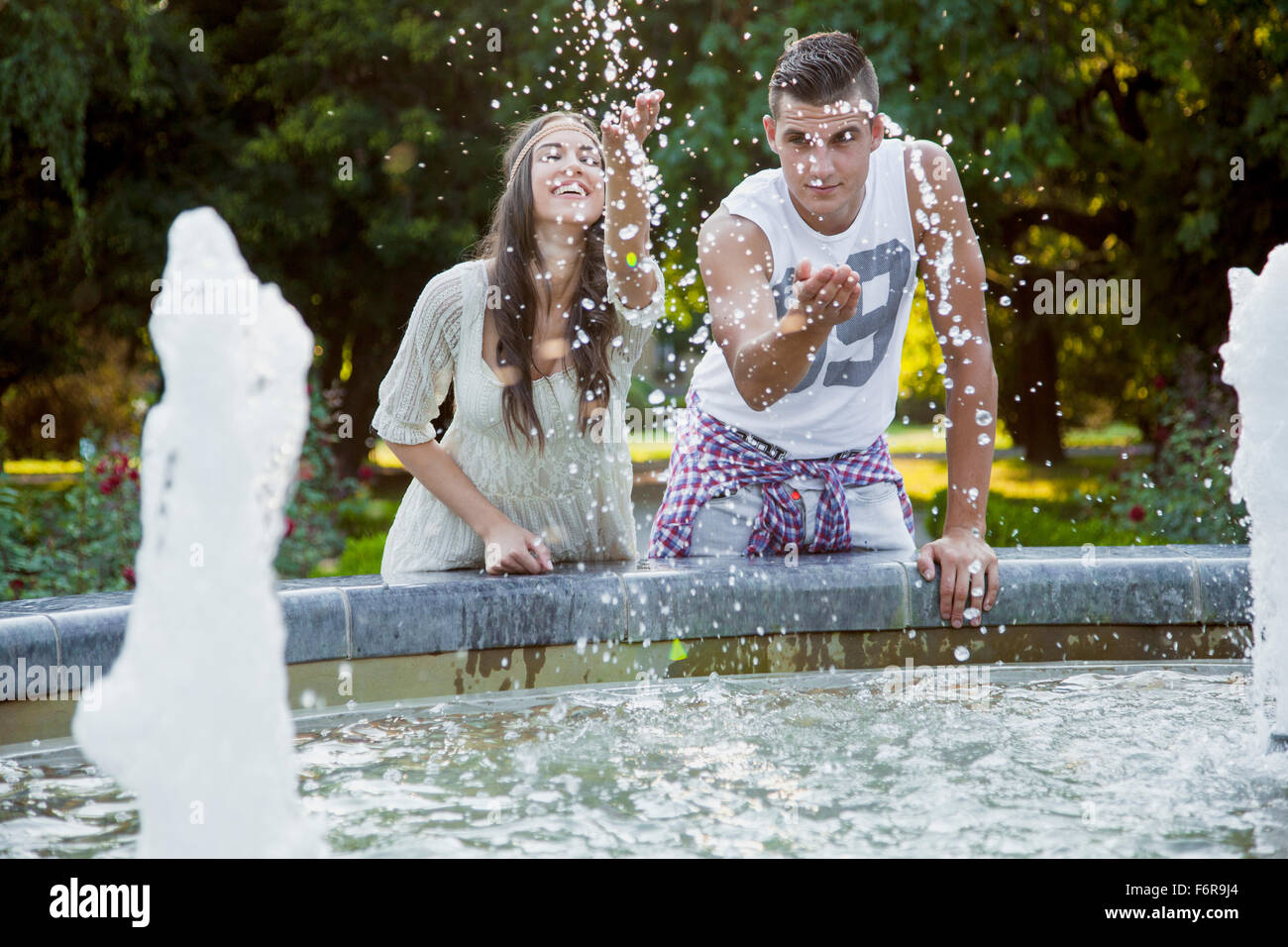 Coppia giovane in stile hippie fashion spruzzi d'acqua Foto Stock