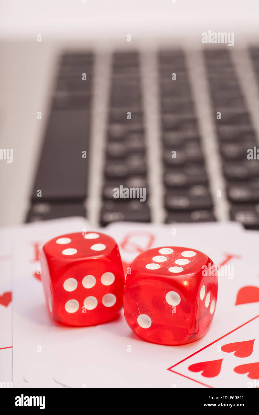 Casino chips, schede e dadi impilamento sul computer portatile Foto Stock