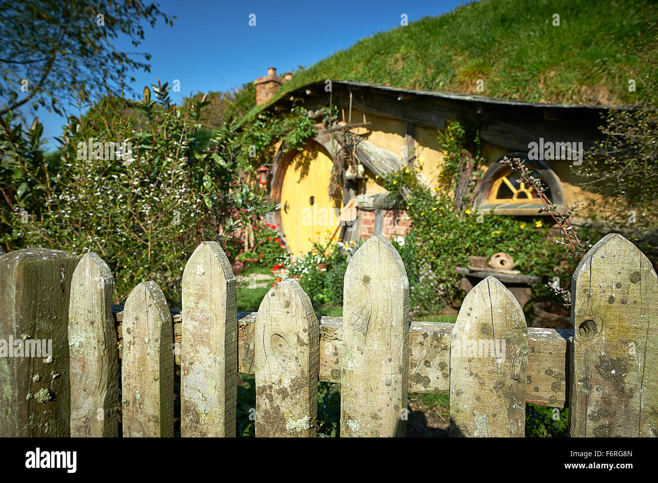 Dettaglio di recinzione con hobbit home in background. Hobbiton Nuova Zelanda Foto Stock
