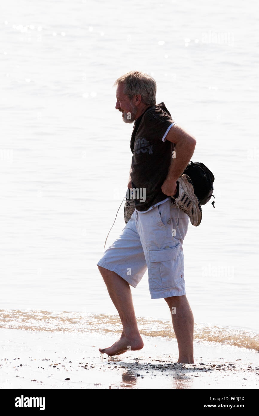 Uomo di affondare nel trasporto di sabbia scarpe pagaiando sulla spiaggia superficie morbida REGNO UNITO Inghilterra Foto Stock