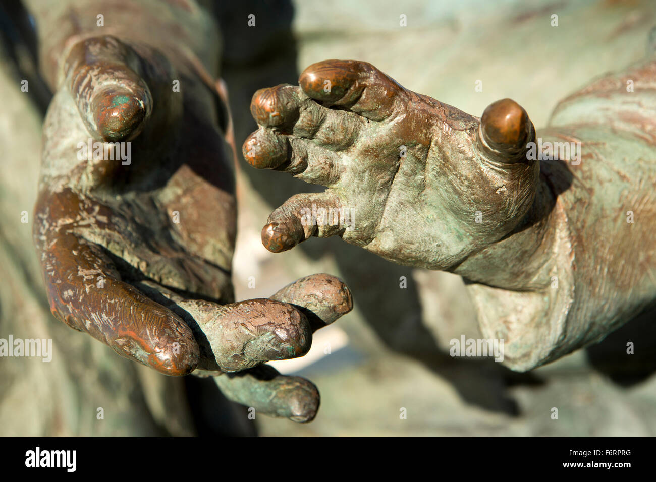 Regno Unito, Inghilterra, nello Yorkshire, Hull, Humber Quays, bronzo adulto e bambino le mani di Neil Hadlock emigranti della scultura Foto Stock