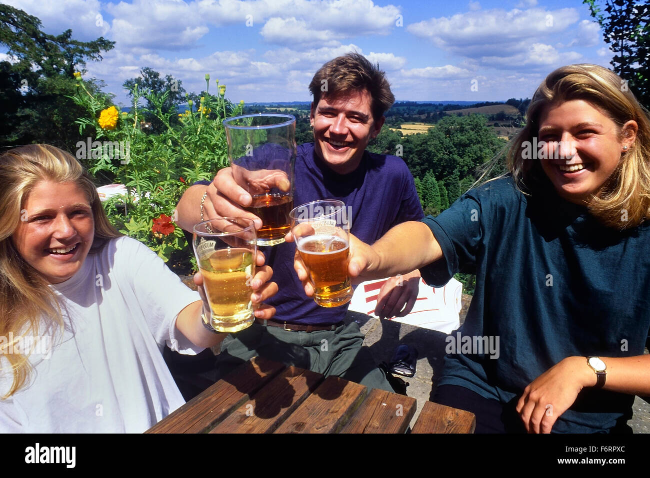 I giovani adulti aumentando il loro occhiali per la fotocamera in The Spotted Dog pub giardino. Penshurst. Kent. In Inghilterra. Regno Unito Foto Stock