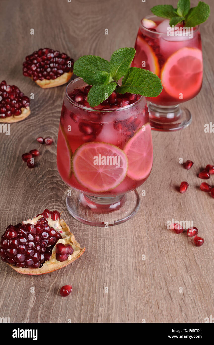 Cocktail di melograno con fettine di lime, menta e ghiaccio Foto Stock