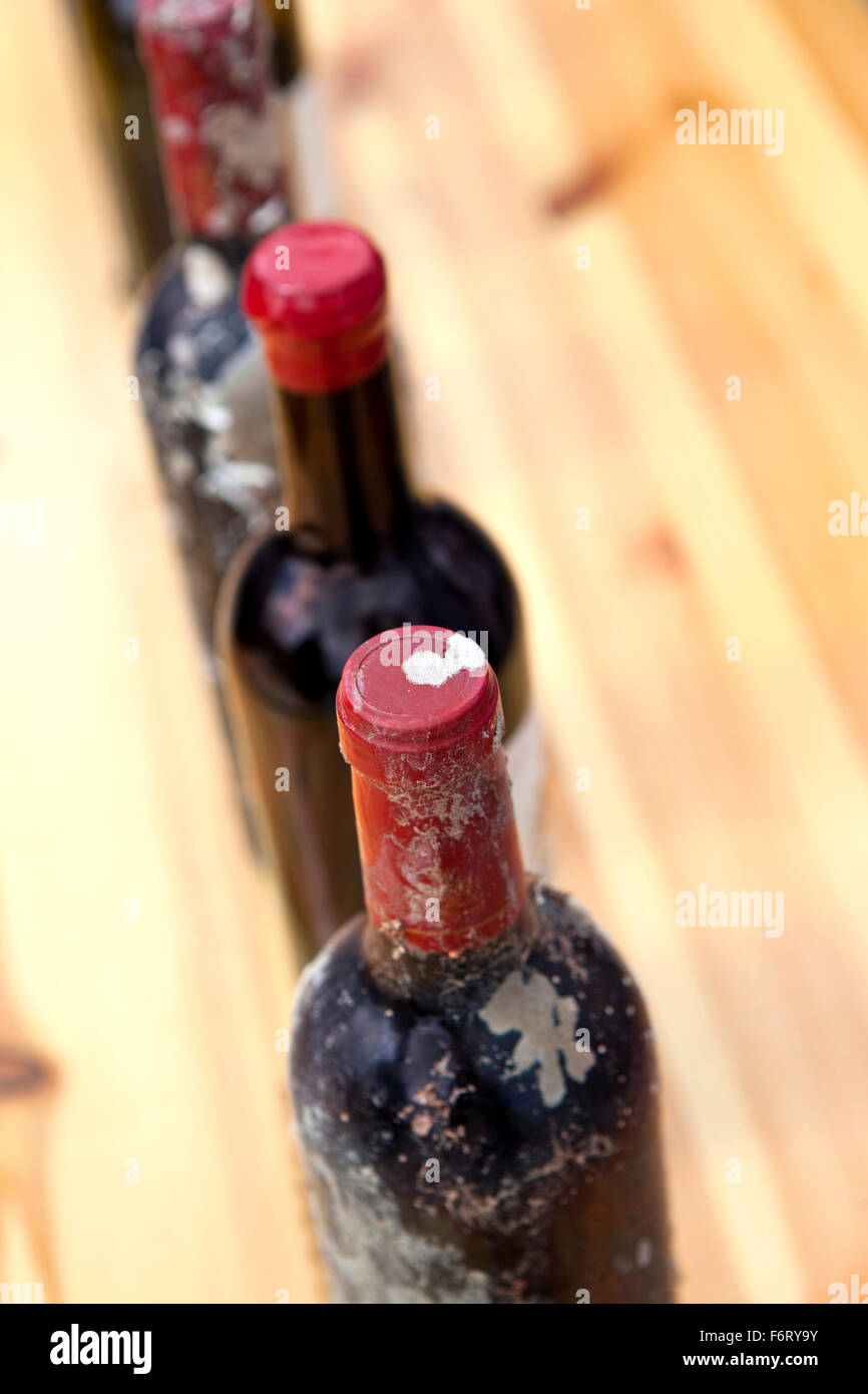 Bottiglie di annata vino rosso in una cantina a Bordeaux Foto Stock