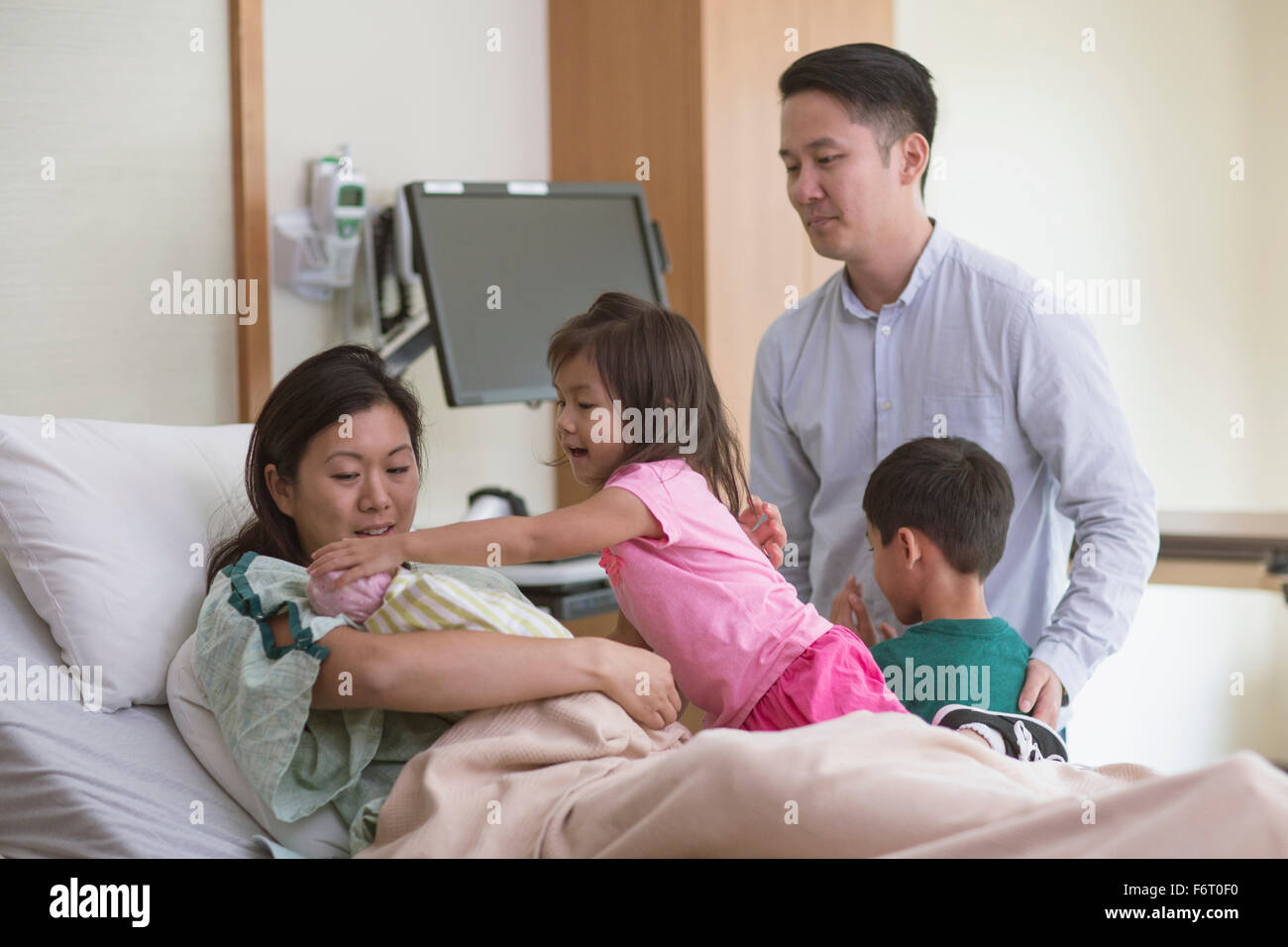 Famiglia ammirando neonato nella stanza di ospedale Foto Stock