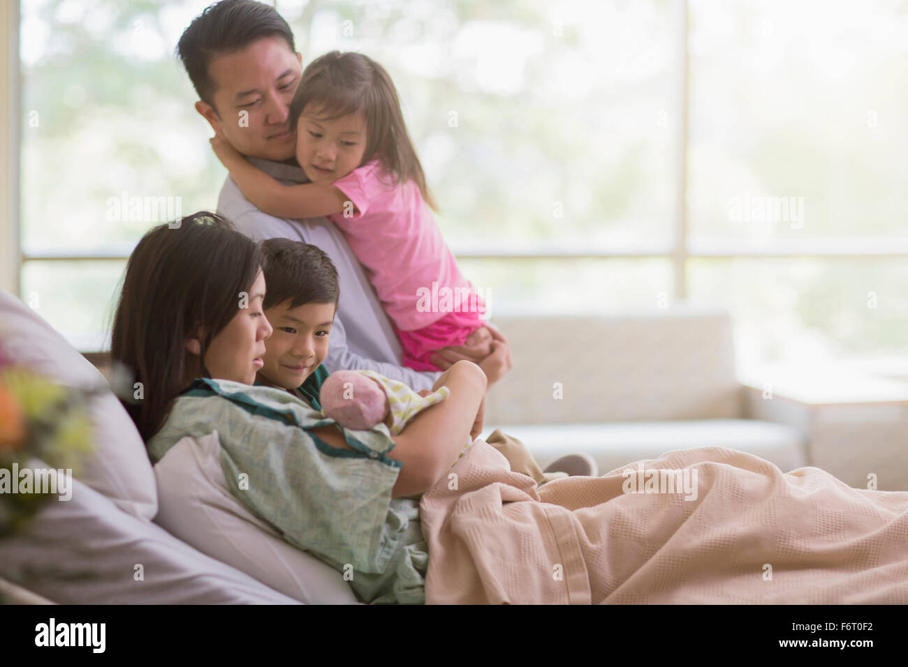 Famiglia ammirando neonato nella stanza di ospedale Foto Stock