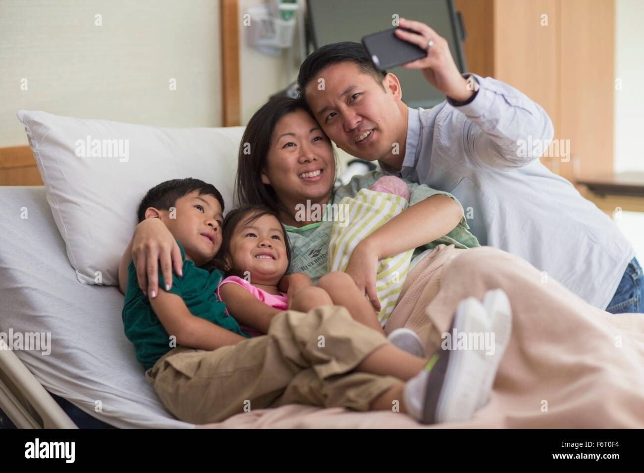 Famiglia tenendo selfie con neonati Foto Stock