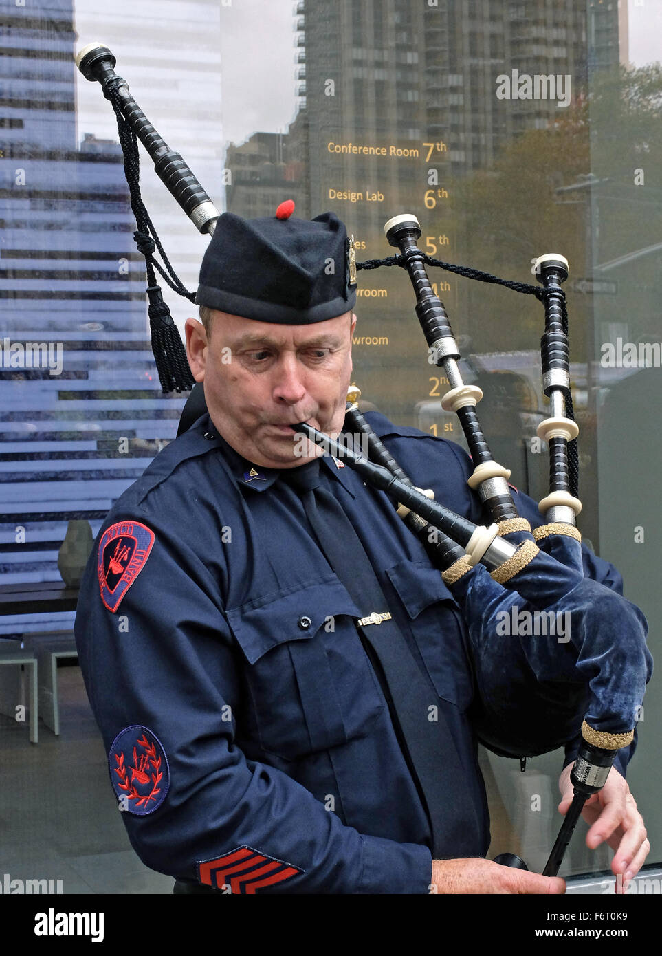 Un membro del New York City Reparto Rettifiche Pipe Band pratica prima di veterani parata del giorno a Manhattan. Foto Stock