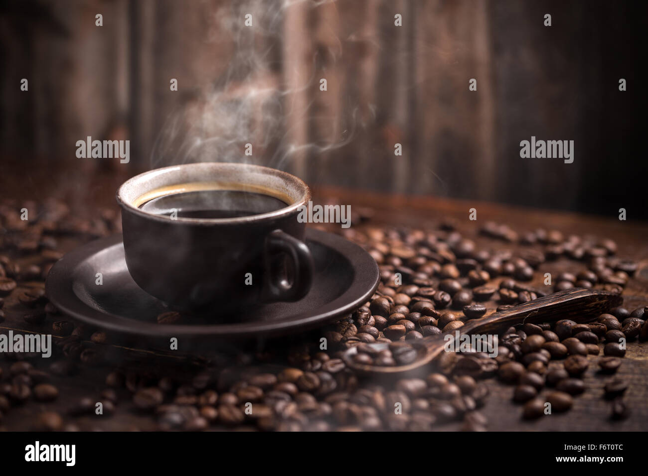 Tazza di caffè e fagioli su uno sfondo di legno. Foto Stock