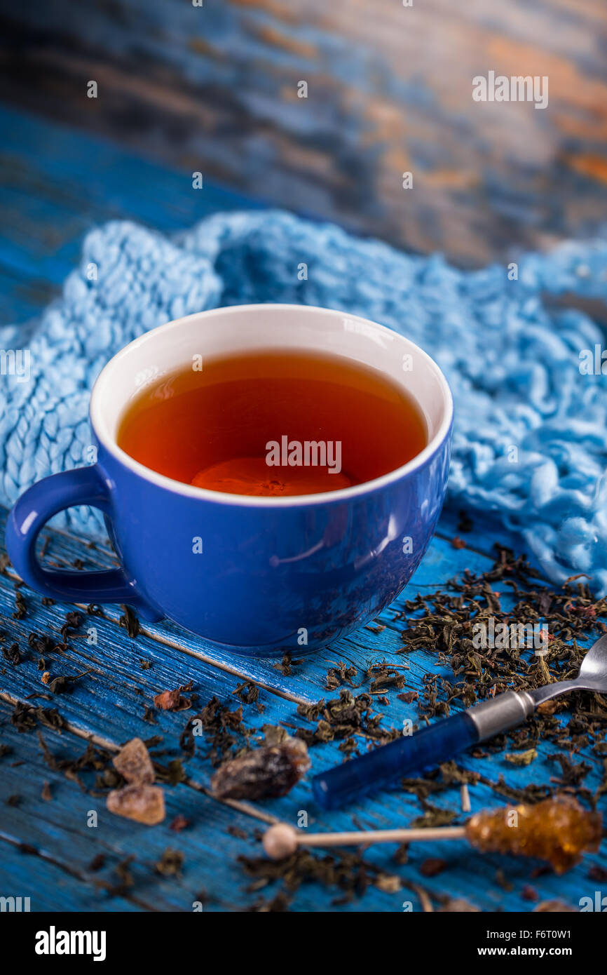 Tazza di tè nero su blu sullo sfondo di legno Foto Stock