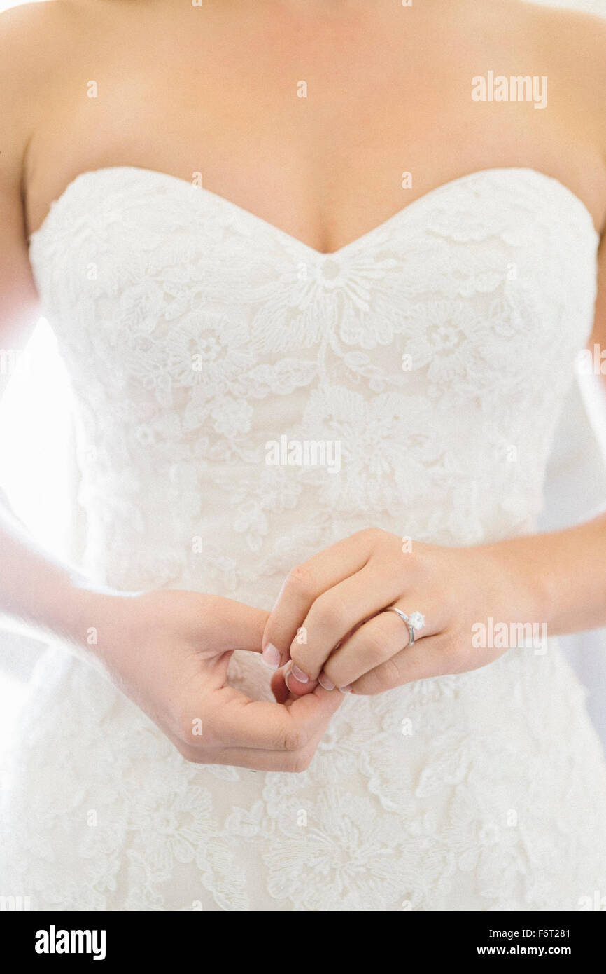 Close up della sposa che indossa abiti da sposa e anello di fidanzamento Foto Stock