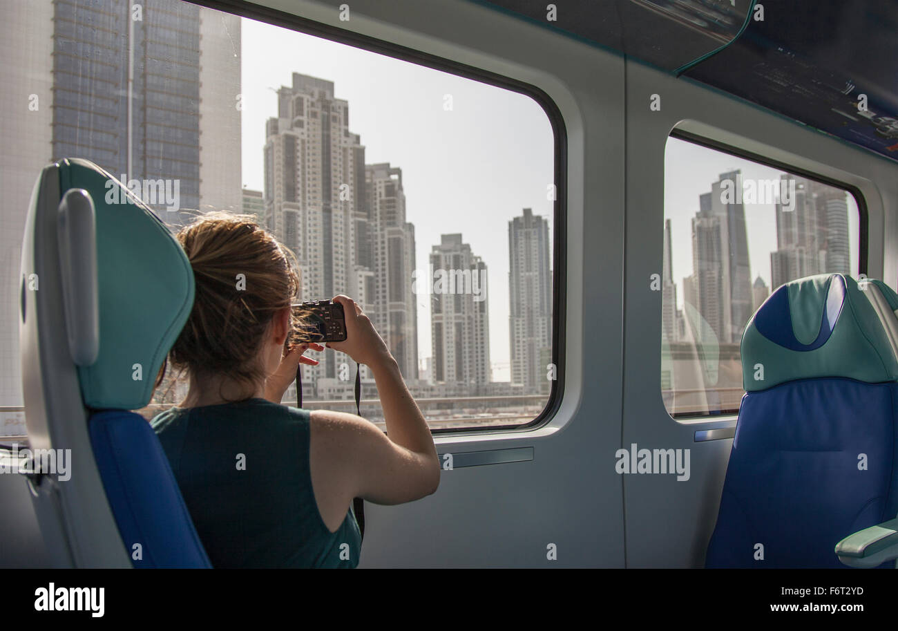La donna caucasica fotografare Dubai cityscape sul treno, Emirato di Dubai, Emirati Arabi Uniti Foto Stock